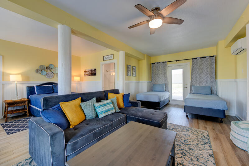 First-floor living area with sofa, queen bed and twin beds